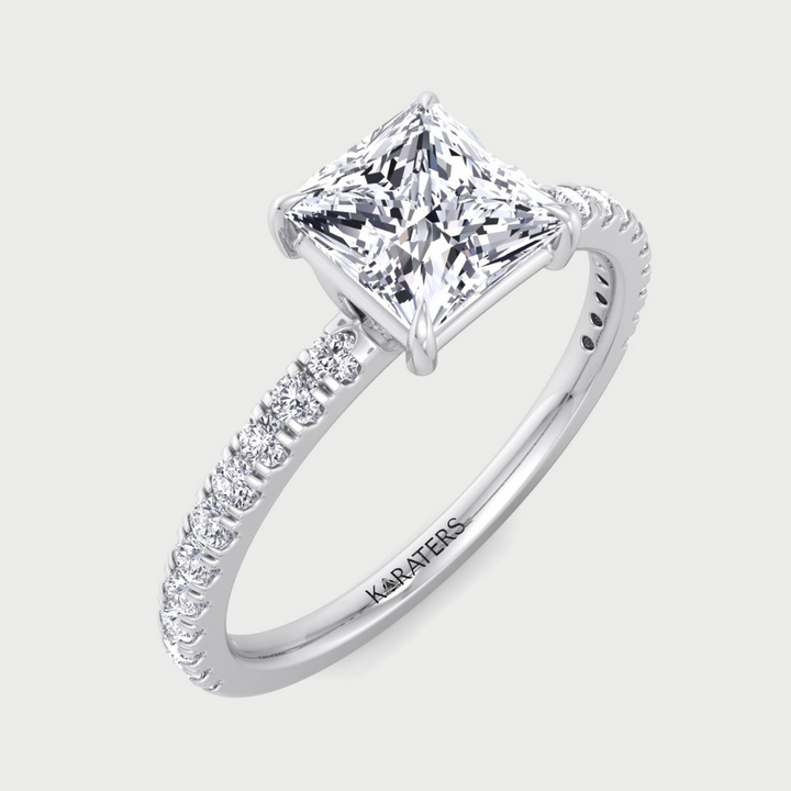 Diamond ring with a princess-cut center stone on a light gray background