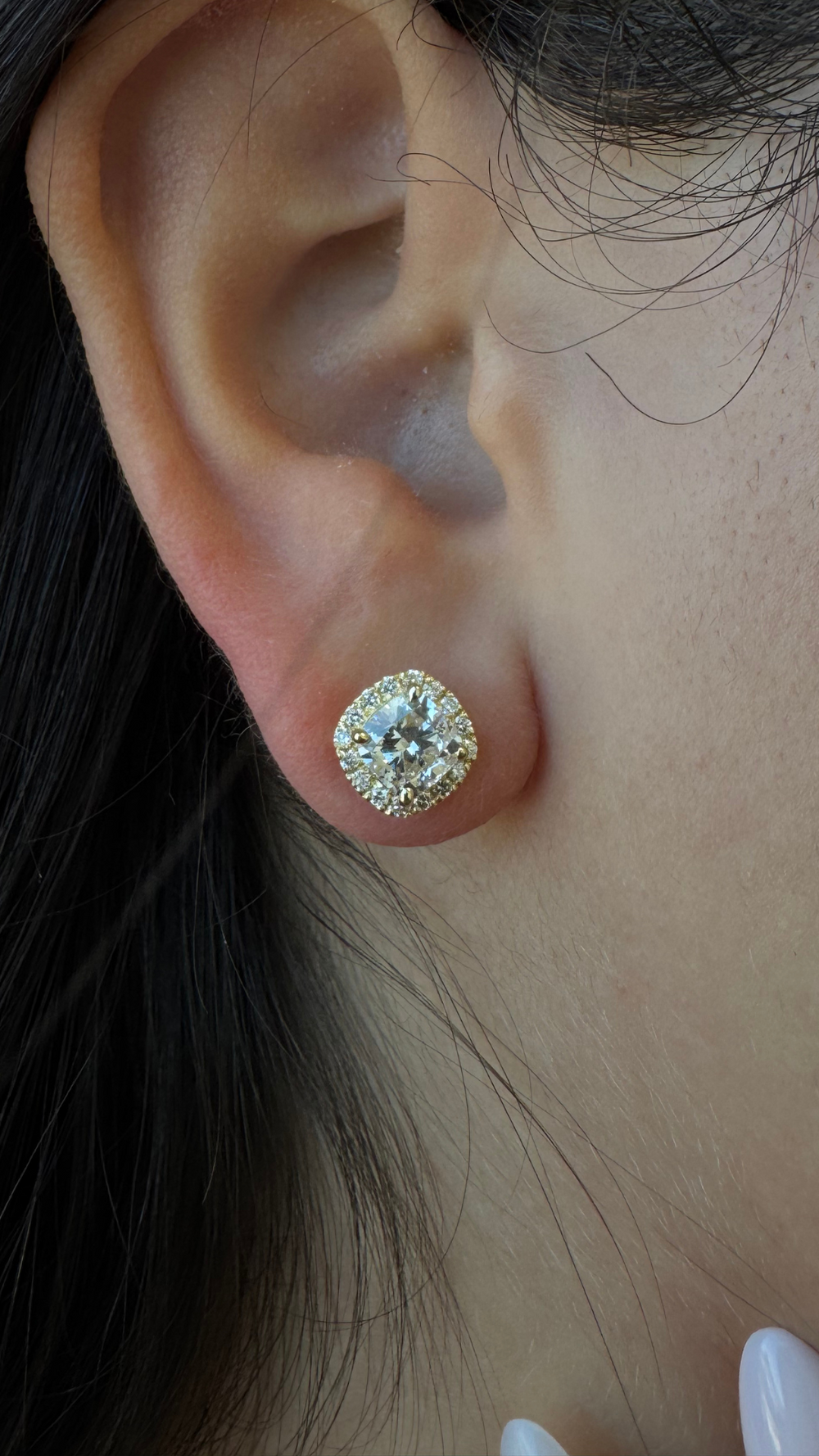 Close-up of an ear wearing a diamond stud earring.