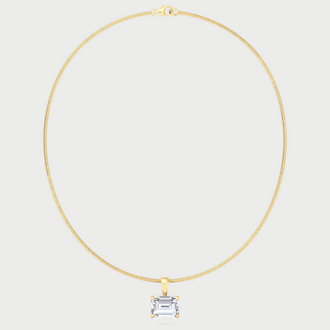 Gold necklace with a square pendant on a light gray background