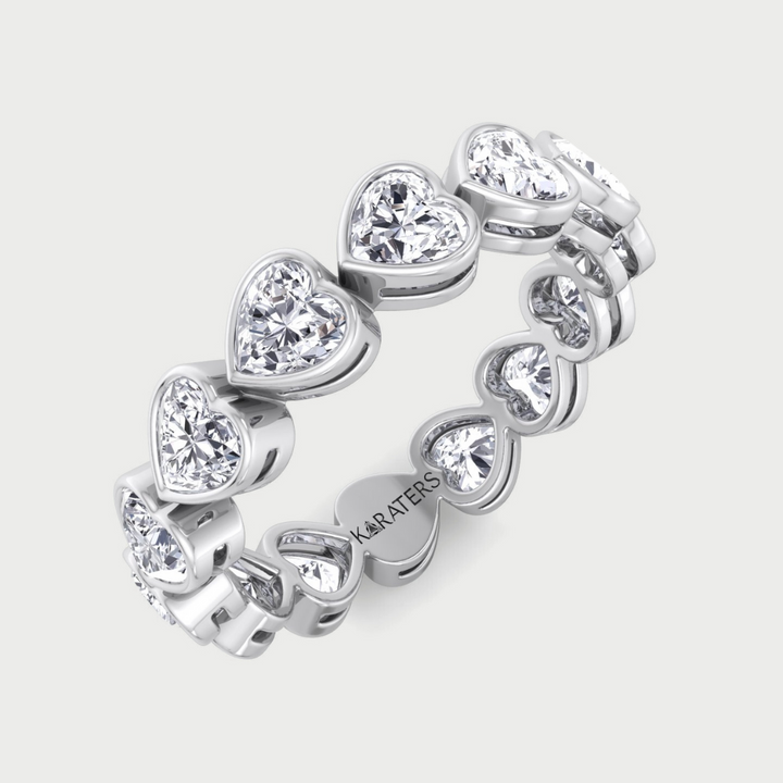 Silver ring with heart-shaped gemstones on a light gray background
