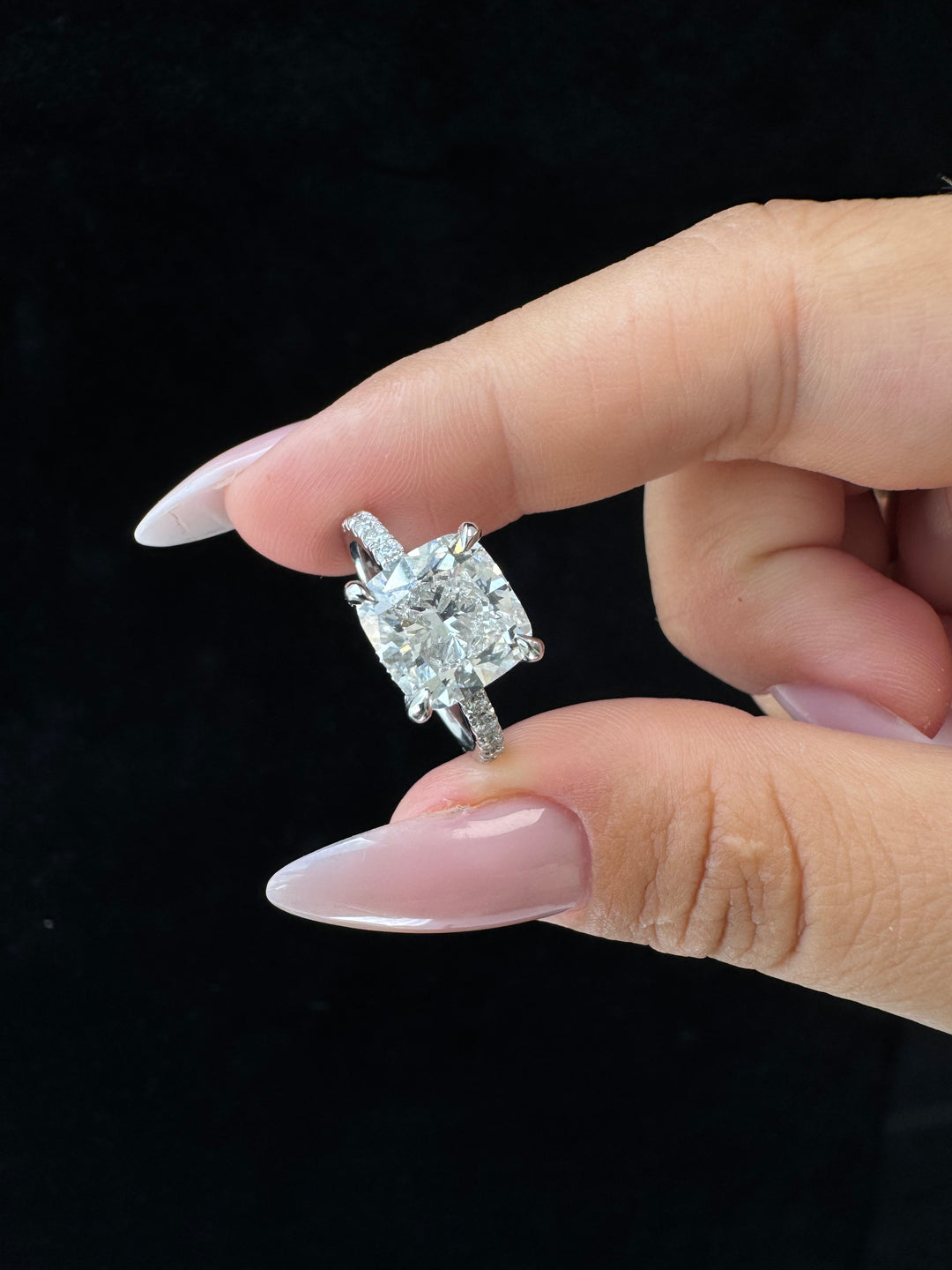 Cushion cut lab grown diamond engagement ring with sidestones and hidden halo