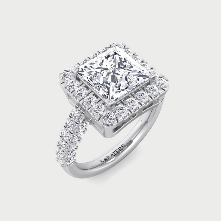 Diamond ring with a prominent central stone and smaller stones around on a light gray background