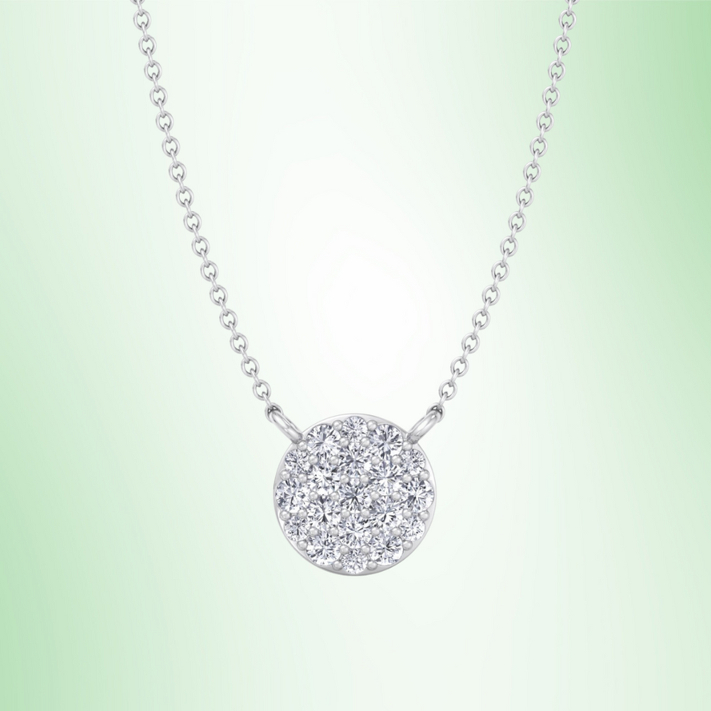 Silver necklace with a round, diamond-studded pendant on a light green background